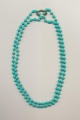 A double or four strand bead necklace made of one necklace and a pearl shortener